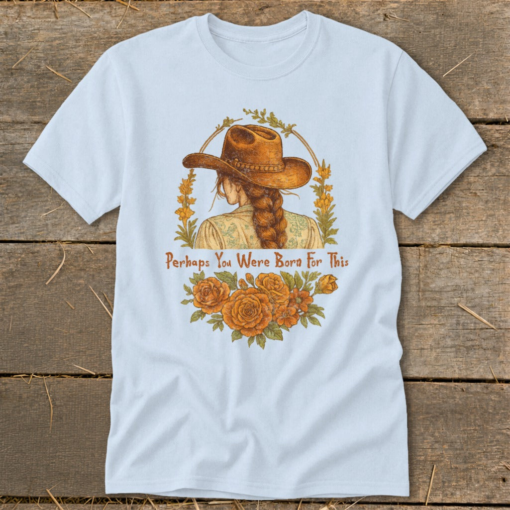 Light blue t-shirt with illustration of woman in cowboy hat, flowers, and text "Perhaps You Were Born For This".