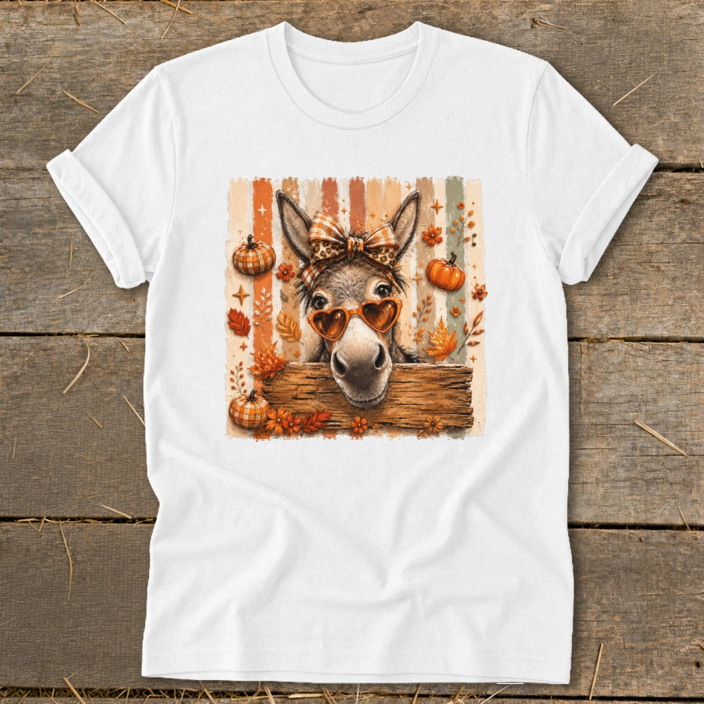Donkey wearing heart sunglasses and a bow with pumpkins and autumn leaves.