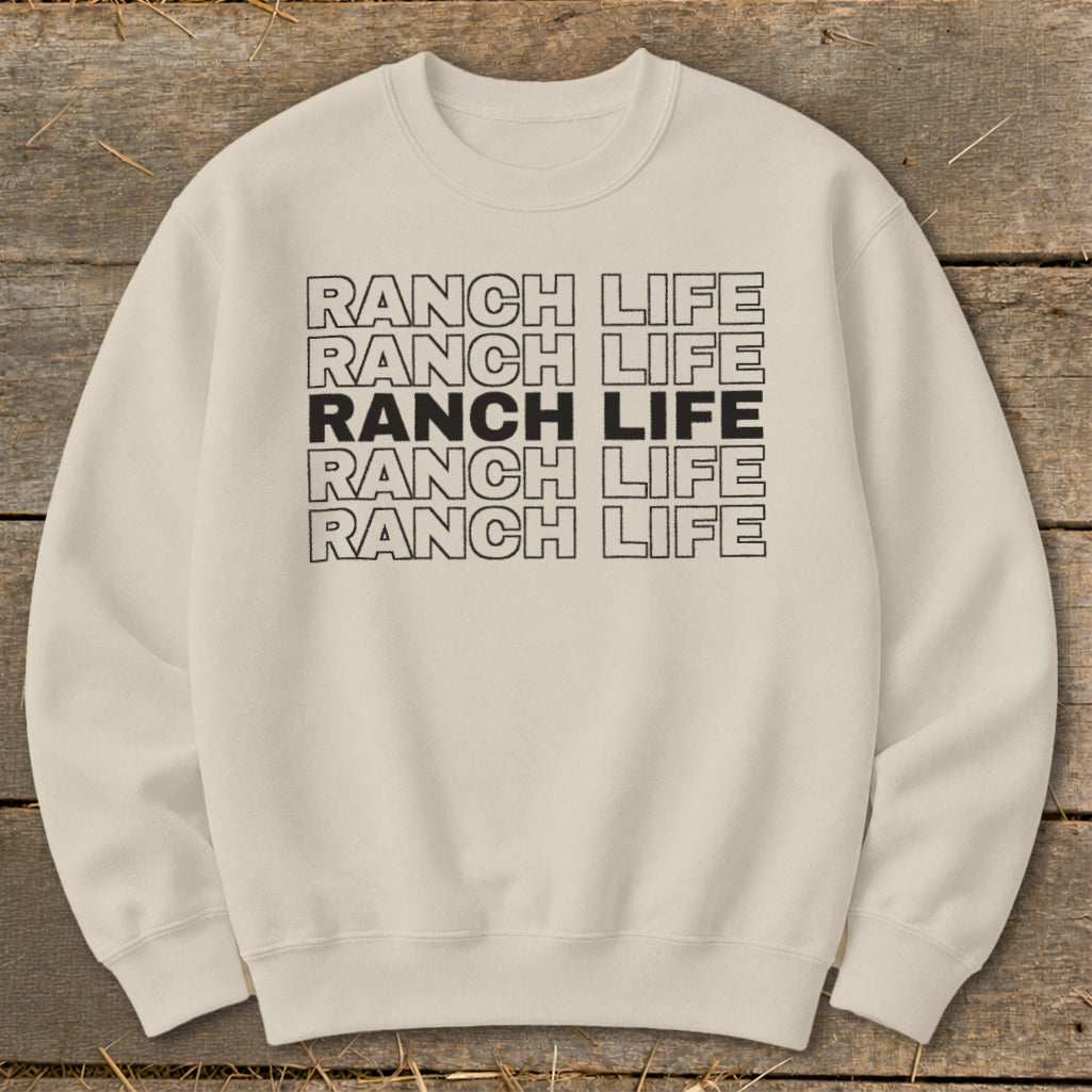 Cream-colored crewneck sweatshirt with repeated black outlined text reading Ranch Life centered on the chest.
