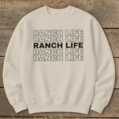 Cream-colored crewneck sweatshirt with repeated black outlined text reading Ranch Life centered on the chest.