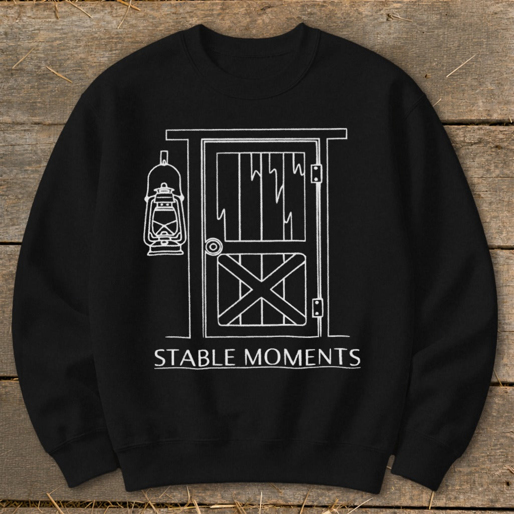 Black sweatshirt with white line drawing of barn door, lantern, and text "STABLE MOMENTS".
