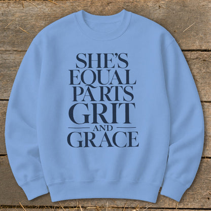 Light blue sweatshirt with "She's Equal Parts Grit and Grace" printed in dark blue.