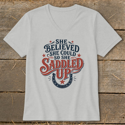 Light gray v-neck t-shirt with "She believed she could so she saddled up" graphic.