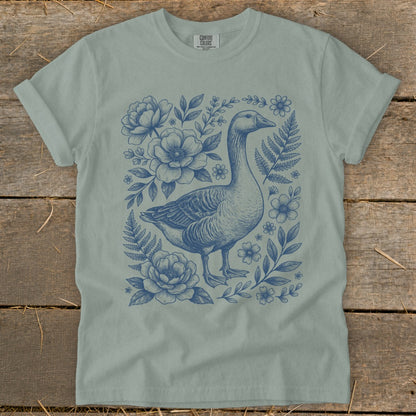 Light sage t-shirt with blue goose and floral illustration.