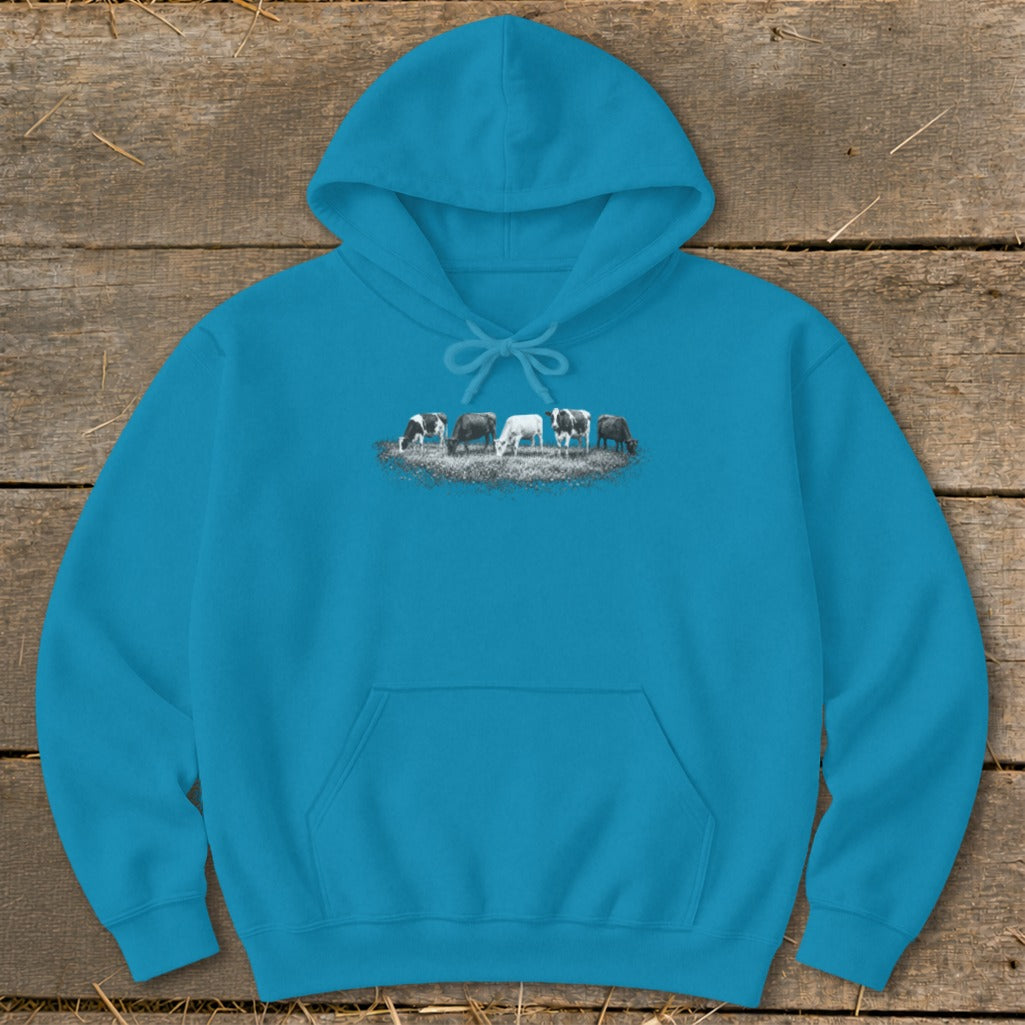 Turquoise hoodie with a graphic of five cows grazing in a field.