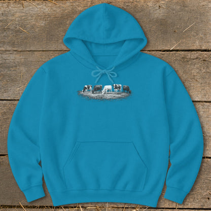 Turquoise hoodie with a graphic of five cows grazing in a field.