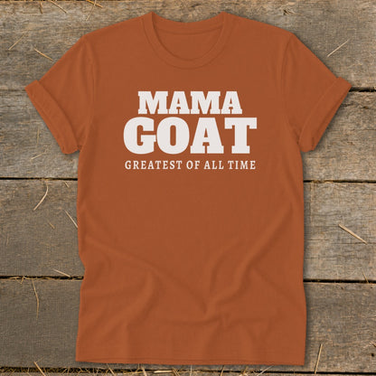 Orange t-shirt with white text reading "MAMA GOAT GREATEST OF ALL TIME".