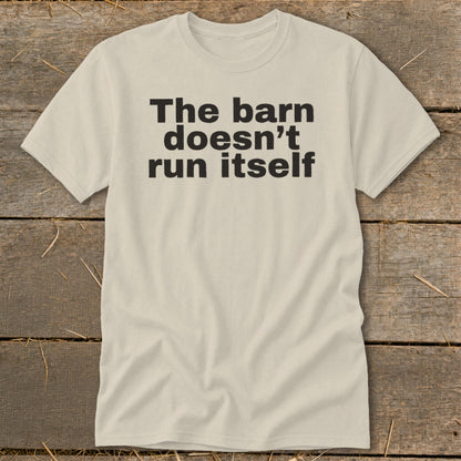 Light tan t-shirt with black text "The barn doesn't run itself."
