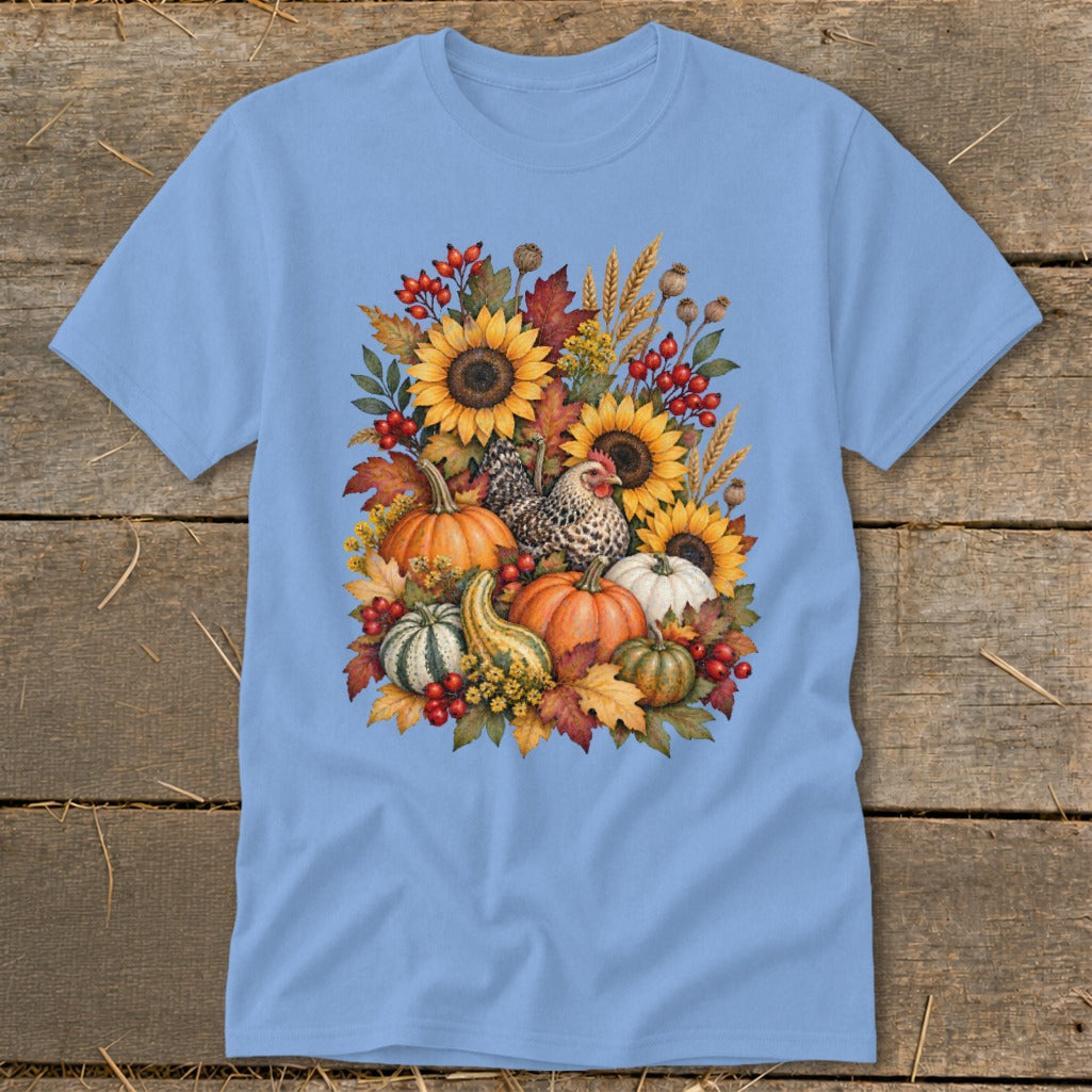 Light blue t-shirt with a watercolor design of sunflowers, pumpkins, gourds, and a chicken.