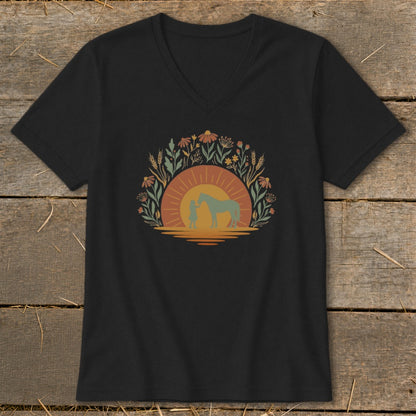 Black t-shirt with a graphic of a person and horse at sunset surrounded by flowers.