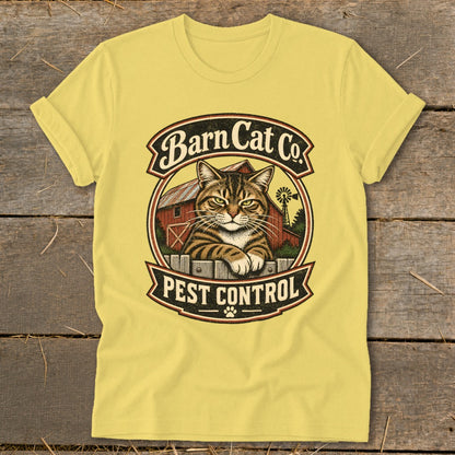 A yellow t-shirt with a vintage-style graphic of a tabby cat resting on a fence with the text Barn Cat Co Pest Control.