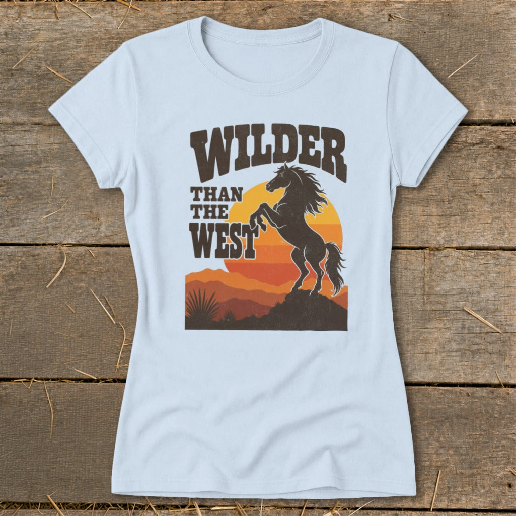 Light blue t-shirt with "WILDER THAN THE WEST" and a silhouetted bucking horse.