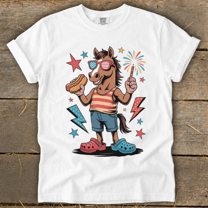 Cartoon horse in sunglasses holding hot dog and sparkler, wearing red striped tank top and denim shorts.