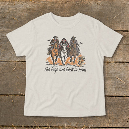 T-shirt graphic featuring three skeleton cowboys on horses and a dog, with text "The boys are back in town."