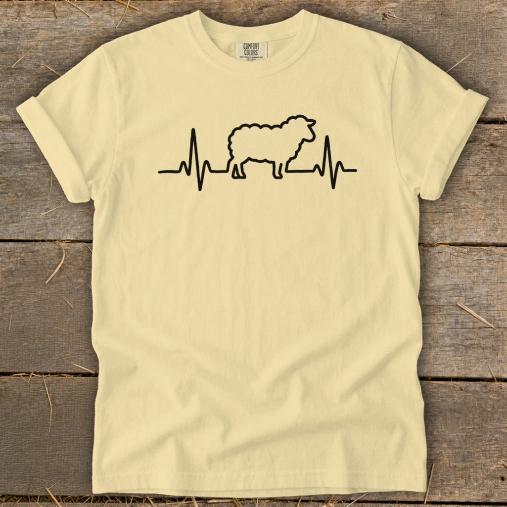 A light yellow t-shirt with a black graphic of a sheep integrated into a heartbeat line.