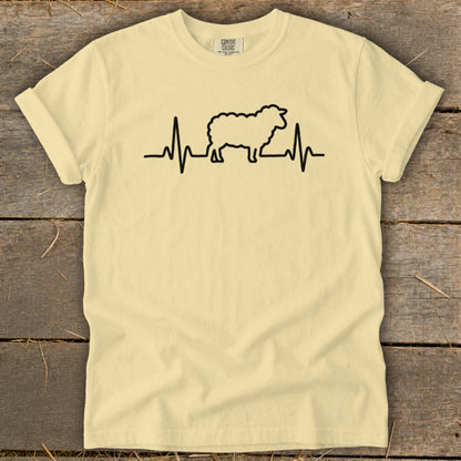 A light yellow t-shirt with a black graphic of a sheep integrated into a heartbeat line.