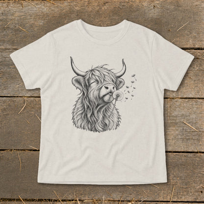 Highland cow with closed eyes blowing on a dandelion.