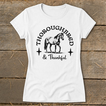 White t-shirt with a graphic of a horse and the text "Thoroughbred & Thankful".