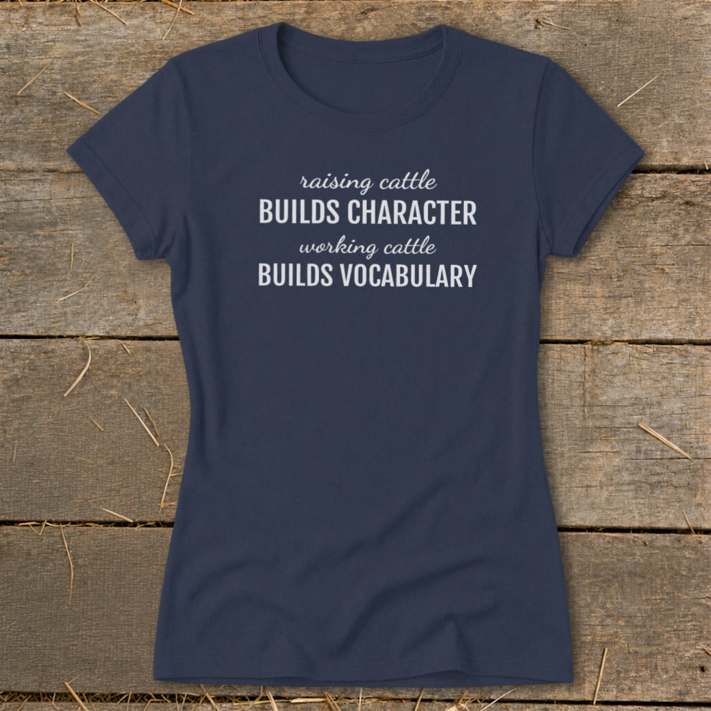 Navy t-shirt with white text reading "raising cattle BUILDS CHARACTER working cattle BUILDS VOCABULARY".