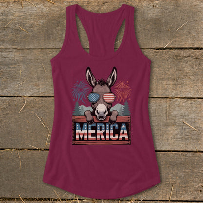 Donkey wearing American flag sunglasses and "MERICA" sign with fireworks background.