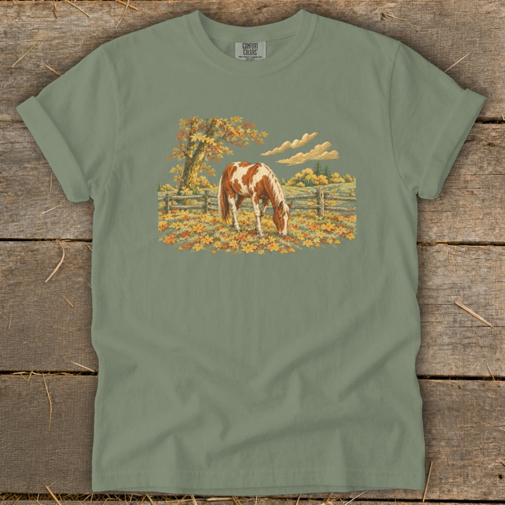 T-shirt with a print of a brown and white horse grazing in an autumn field.