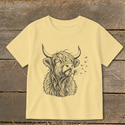 T-shirt with sketch of Highland cow blowing a dandelion.