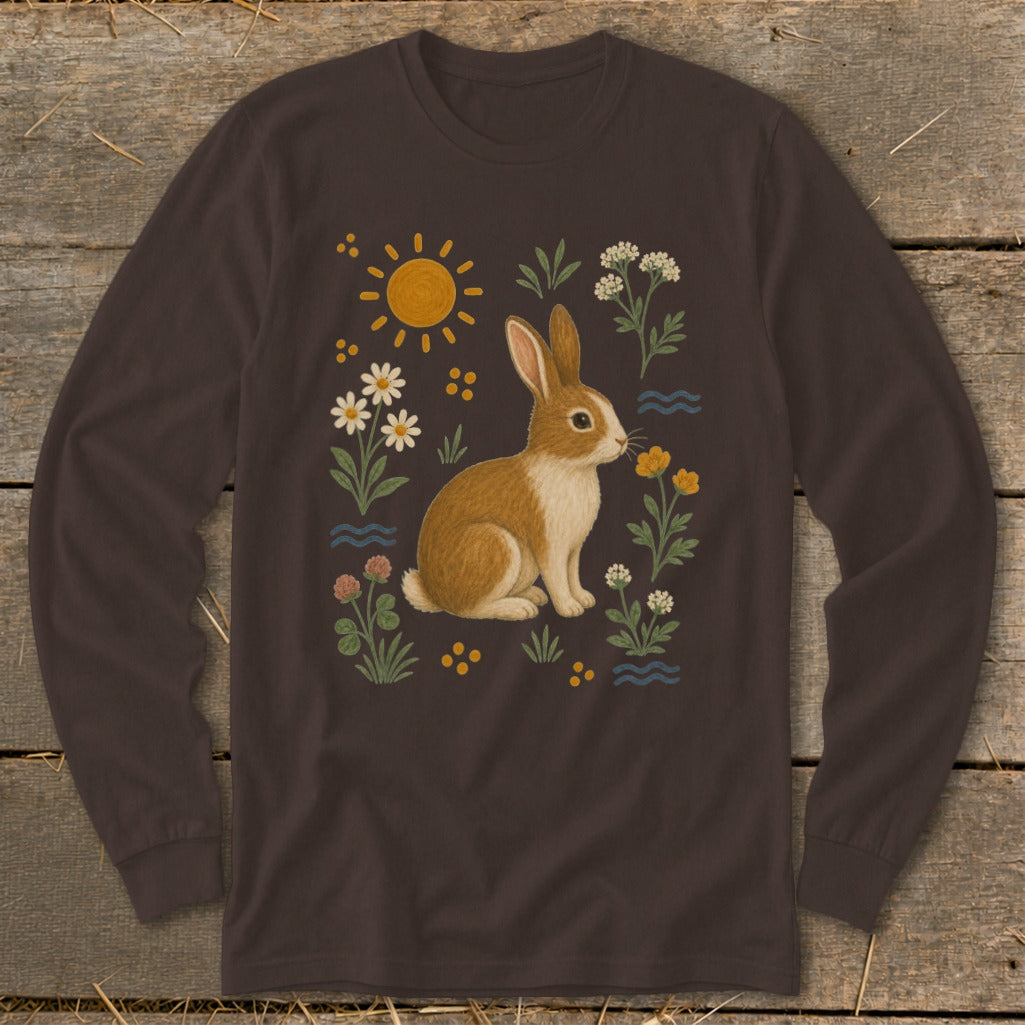 Brown long-sleeve shirt with a whimsical bunny illustration surrounded by flowers and sun.