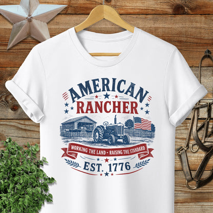 White t-shirt with "American Rancher" and "Est. 1776" text and farm graphic.