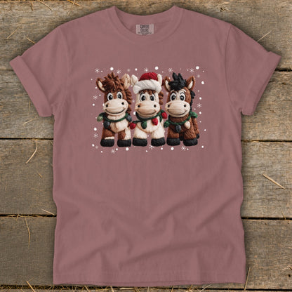 Three cartoon horses in Christmas attire with snowflakes.