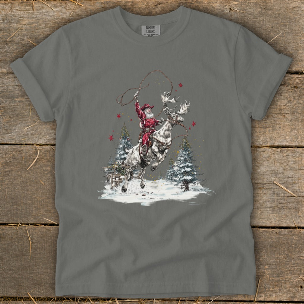 Santa lassoing a bucking reindeer in a snowy western landscape.
