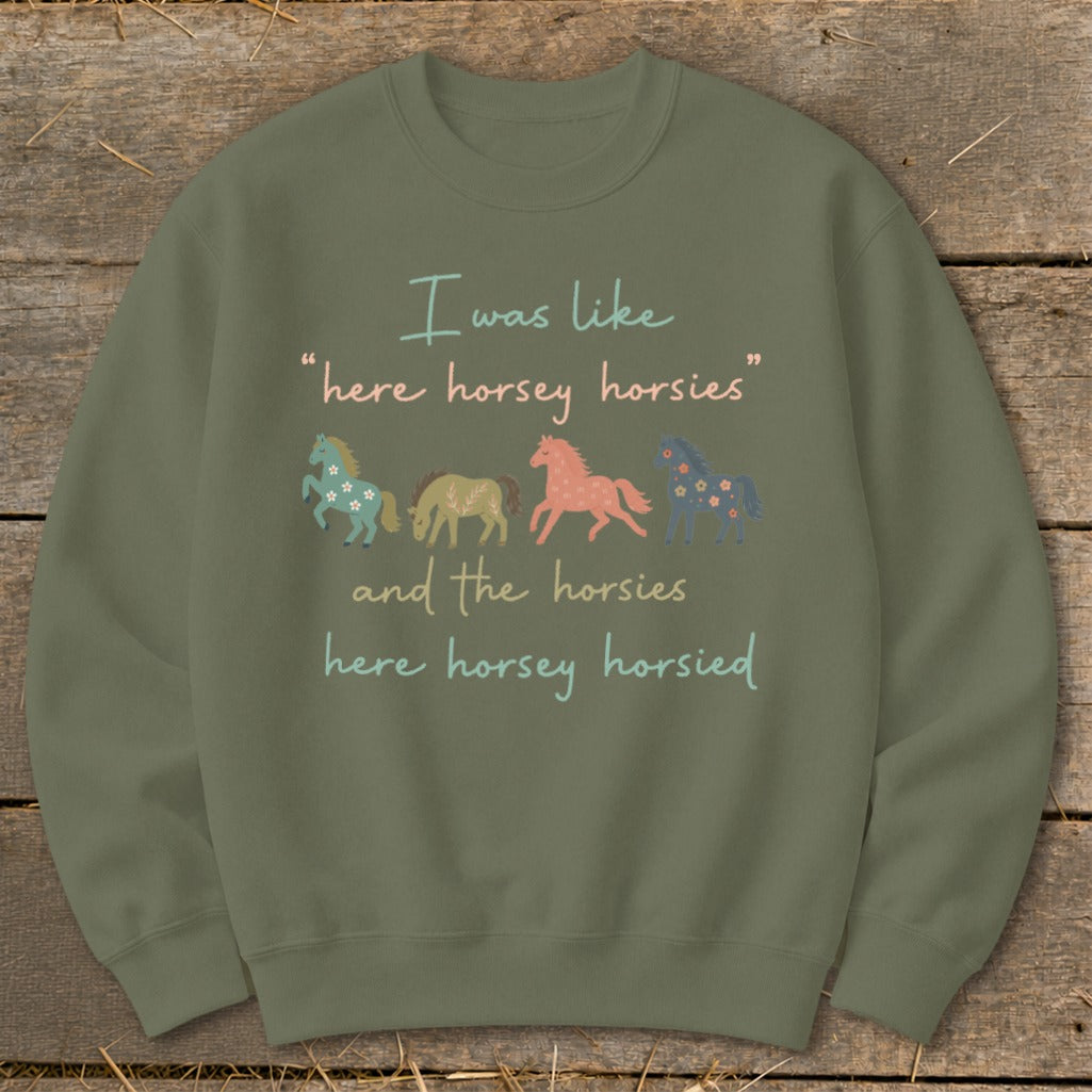 Green sweatshirt with text and four illustrated horses, two floral.