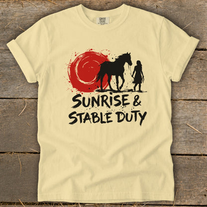 T-shirt graphic with black silhouette of horse and rider against red sun. Text reads "SUNRISE & STABLE DUTY".
