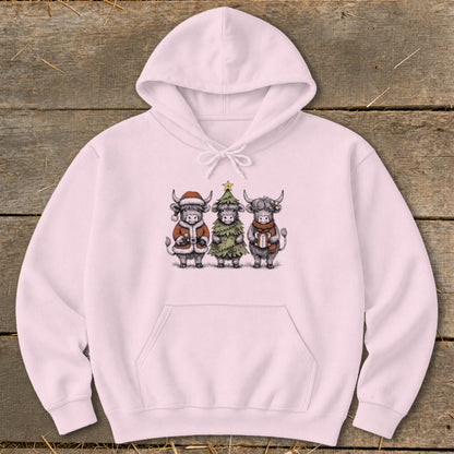 Pink hoodie with a Christmas-themed drawing of three highland cows.