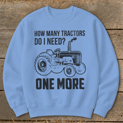 Light blue sweatshirt with black tractor graphic and text: "How Many Tractors Do I Need? One More"