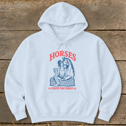 White hoodie with graphic of woman and horse, text "HORSES CHEAPER THAN THERAPY".