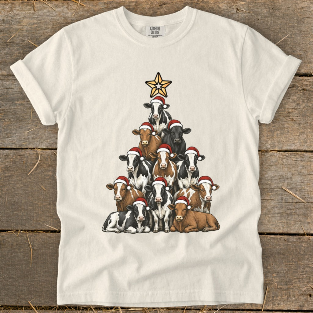 Cream t-shirt with a Christmas tree shape made of cows wearing Santa hats.