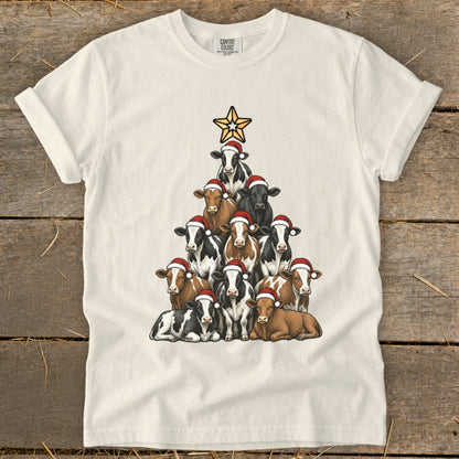 Cream t-shirt with a Christmas tree shape made of cows wearing Santa hats.