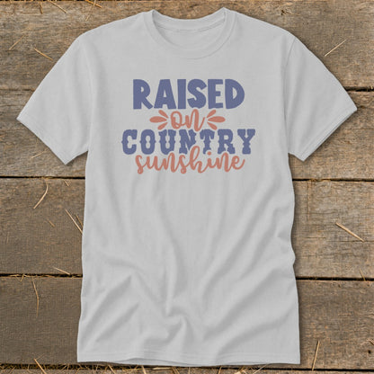 Light gray t-shirt with "RAISED ON COUNTRY SUNSHINE" text in blue and pink.