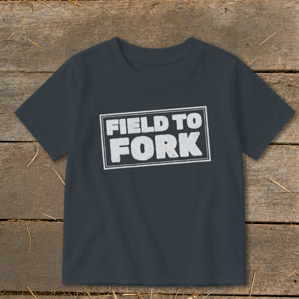 Dark gray children's t-shirt featuring the white distressed text "FIELD TO FORK" inside a double-lined rectangular box.