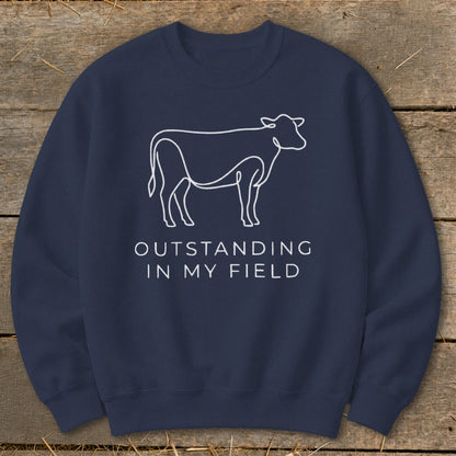 Navy sweatshirt with white cow outline and text "OUTSTANDING IN MY FIELD".
