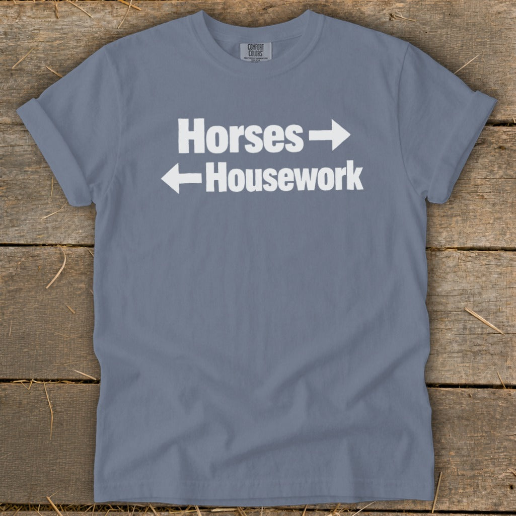 A grey short-sleeved t-shirt with white text reading Horses and Housework, paired with directional arrows.