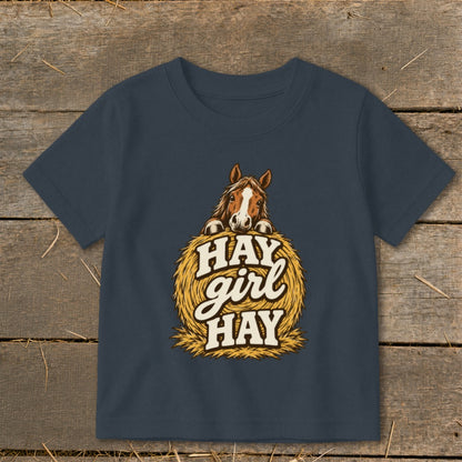 Children's dark blue t-shirt with horse peeking over hay bale, text "Hay girl Hay".