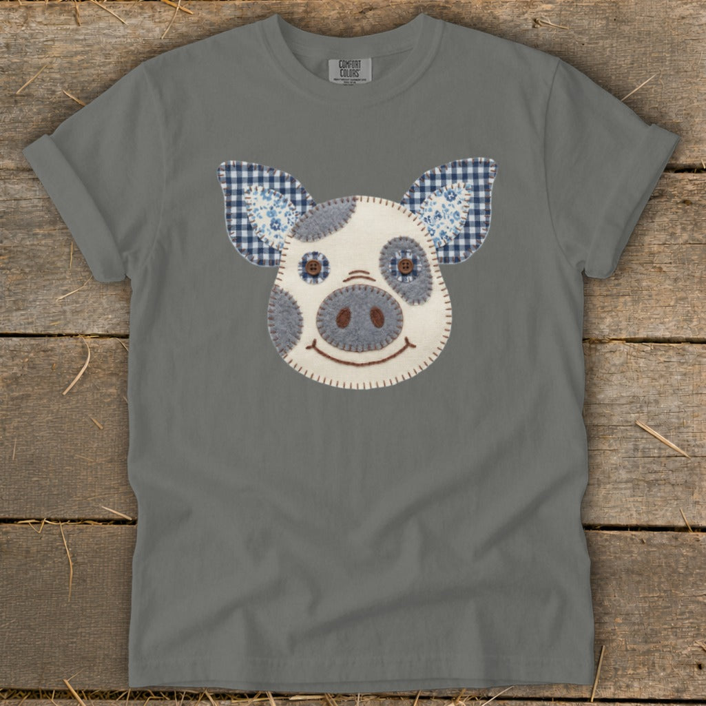 Gray t-shirt with a patchwork pig face graphic featuring blue checkered ears.