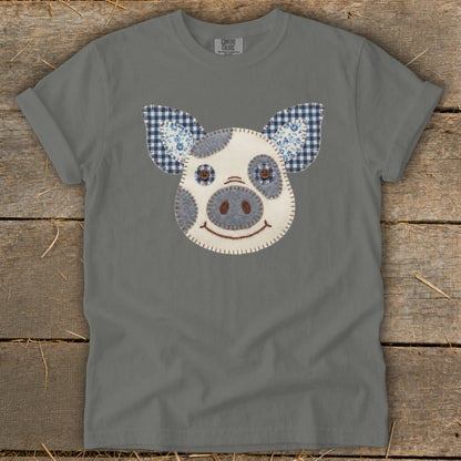Gray t-shirt with a patchwork pig face graphic featuring blue checkered ears.