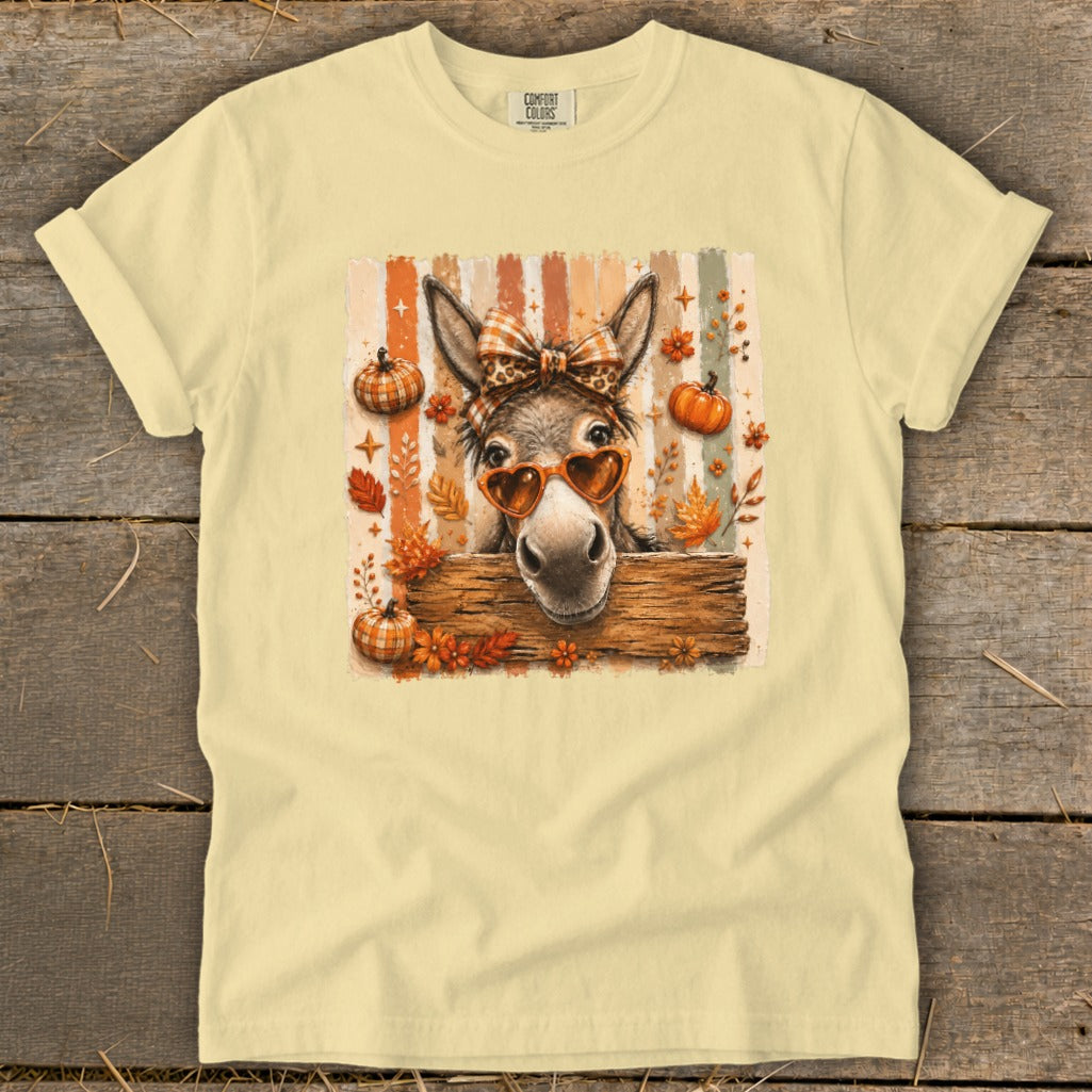 Donkey with heart sunglasses and fall leaves on a cream t-shirt.