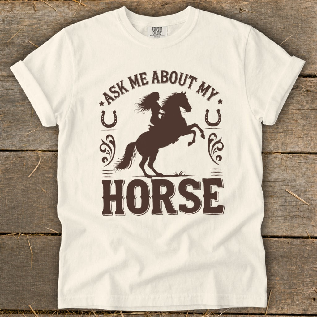 T-shirt with brown graphic of person riding rearing horse and text "Ask Me About My Horse".