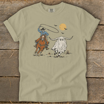 Skeleton cowboy on horseback lassoing a longhorn bull ghost with bats and moon overhead.