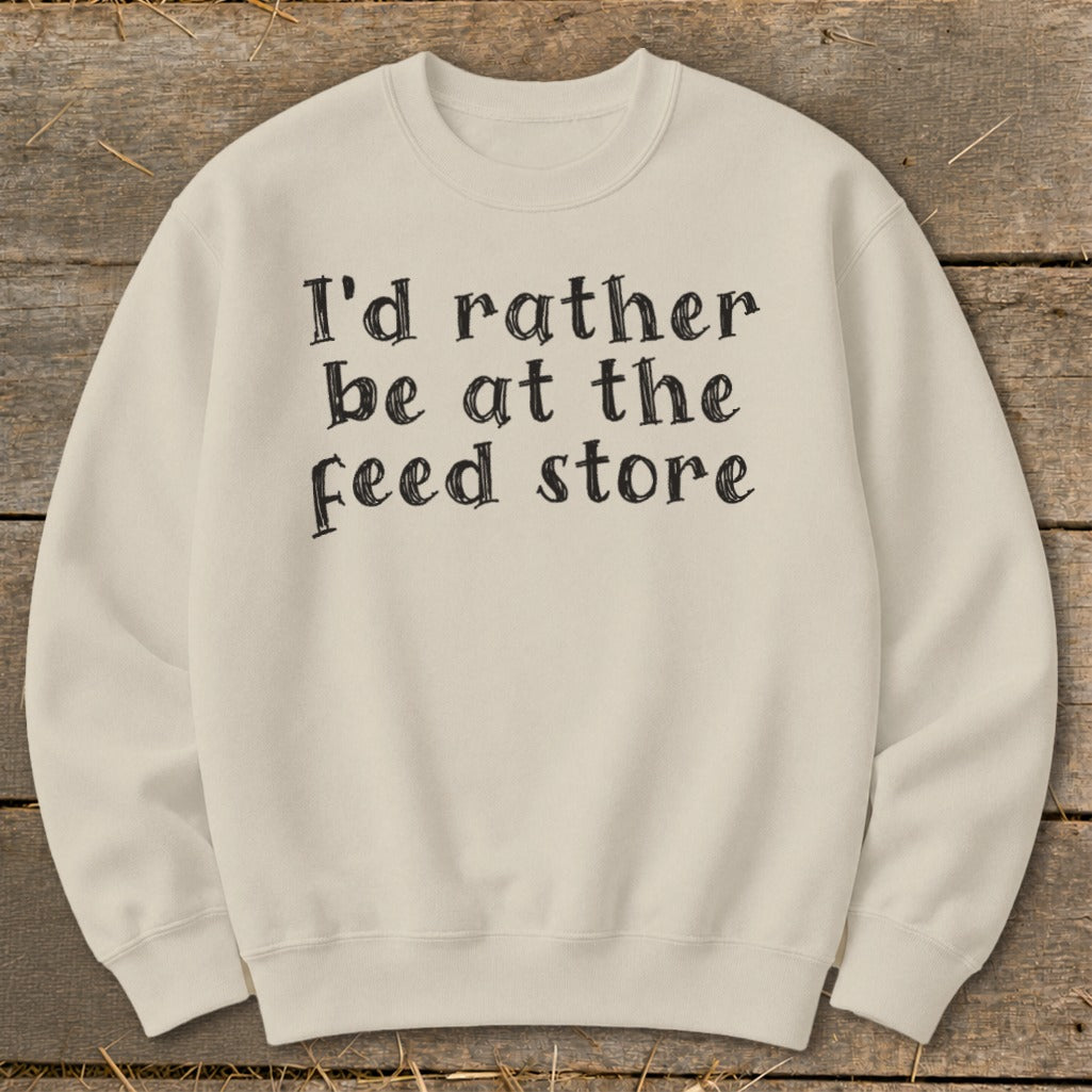 Cream sweatshirt with black text that reads "I'd rather be at the feed store."
