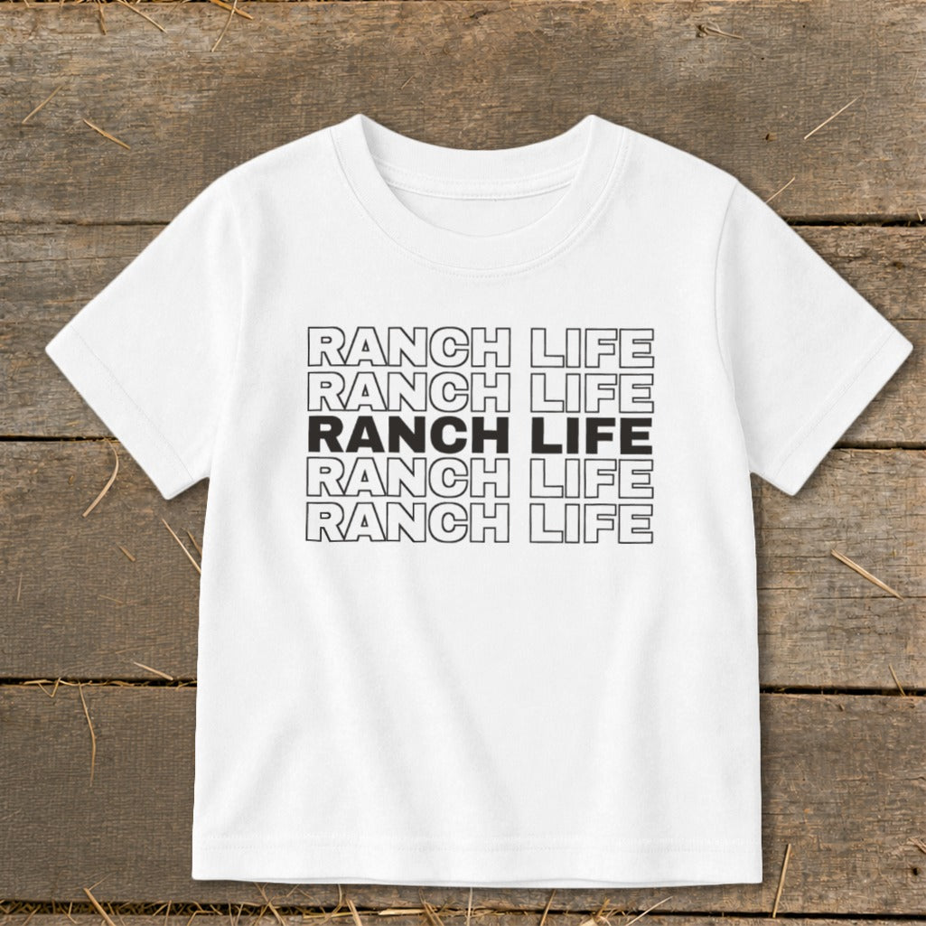 A white short-sleeved t-shirt with five rows of repeated black text reading RANCH LIFE.