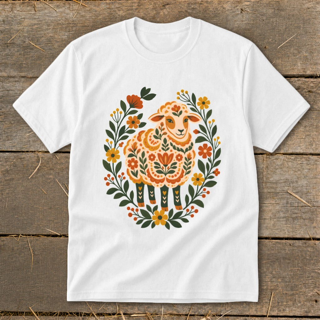 White t-shirt with a folk art sheep illustration surrounded by flowers and leaves.